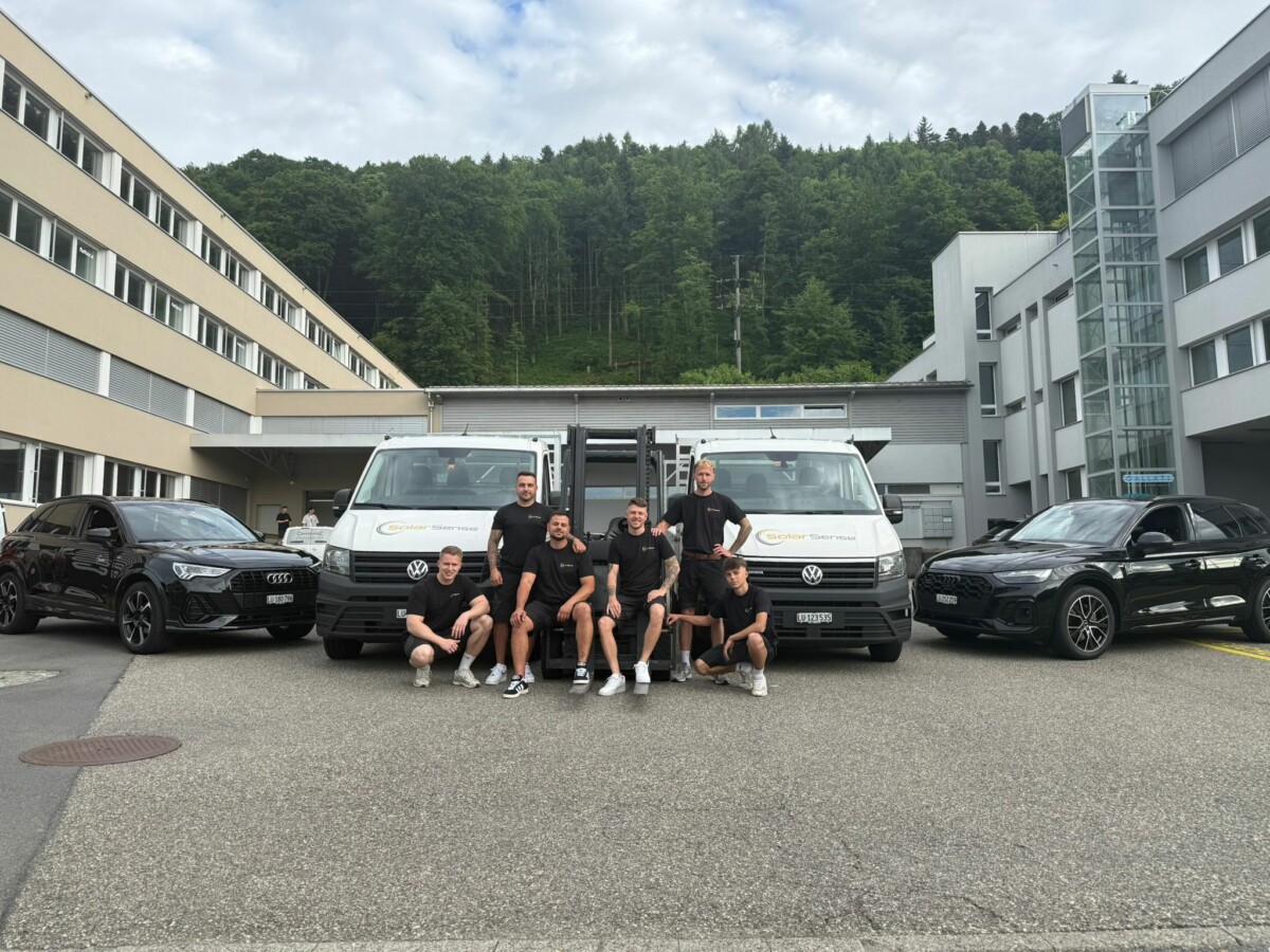 Gruppenbild des SolarSense-Teams auf dem Firmenareal in Luzern, im Hintergrund bewaldeter Hang.
